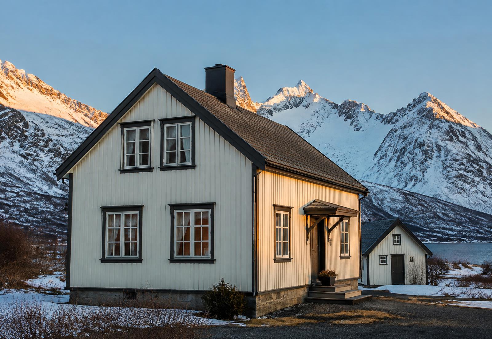 Nyoppmalt trehus med fjell i bakgrunnen